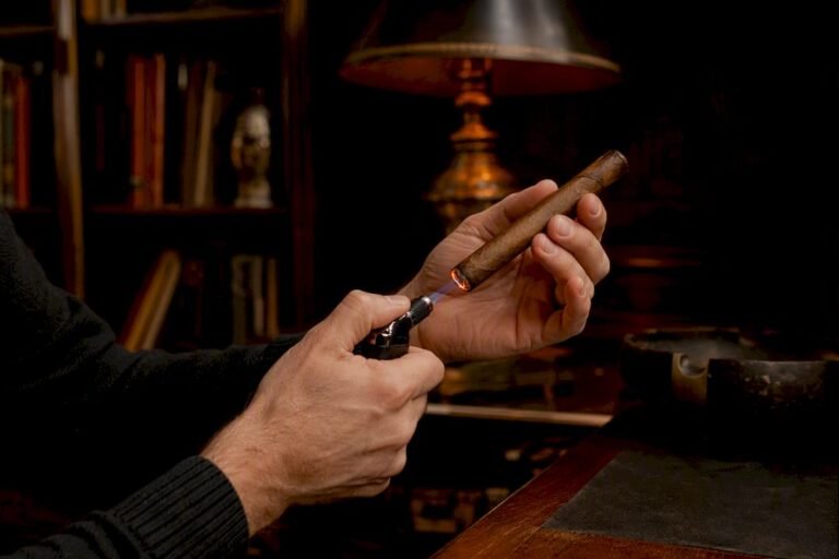 Hand holding torch to fix cigar burn