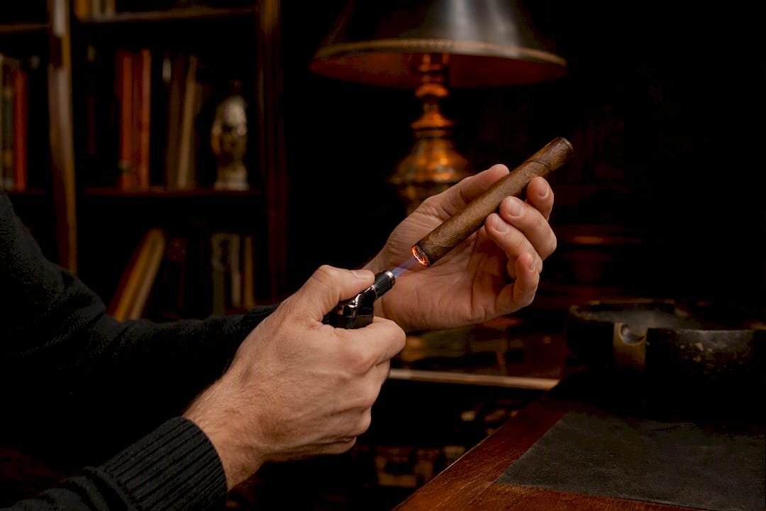 Hand holding torch to fix cigar burn