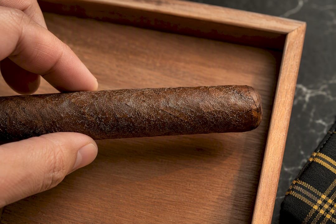Fingertips inspecting crystalline plume on wrapper