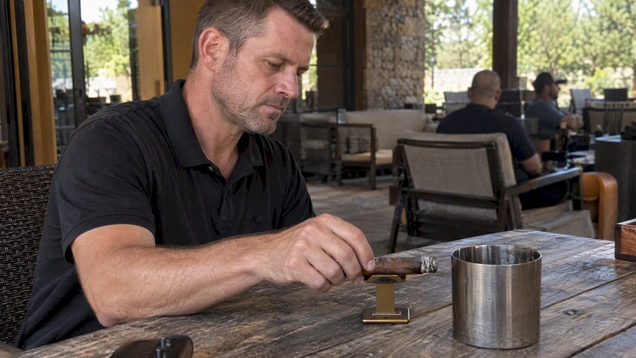 Cigar resting on a stand beside a metal cup